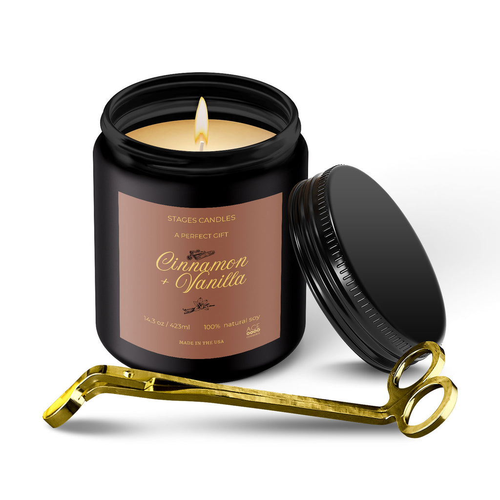 Cinnamon and vanilla scented candle in a black jar with a gold wick trimmer.