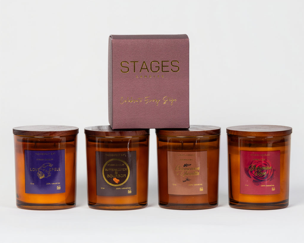 Four amber glass candles with labels and a 'STAGES' branded box